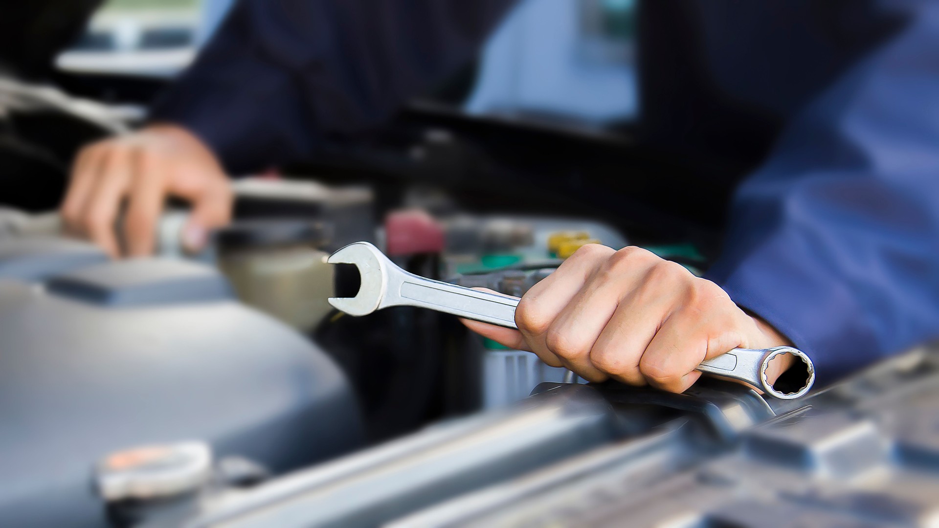 Car mechanic working on car engine, car maintenance concept.